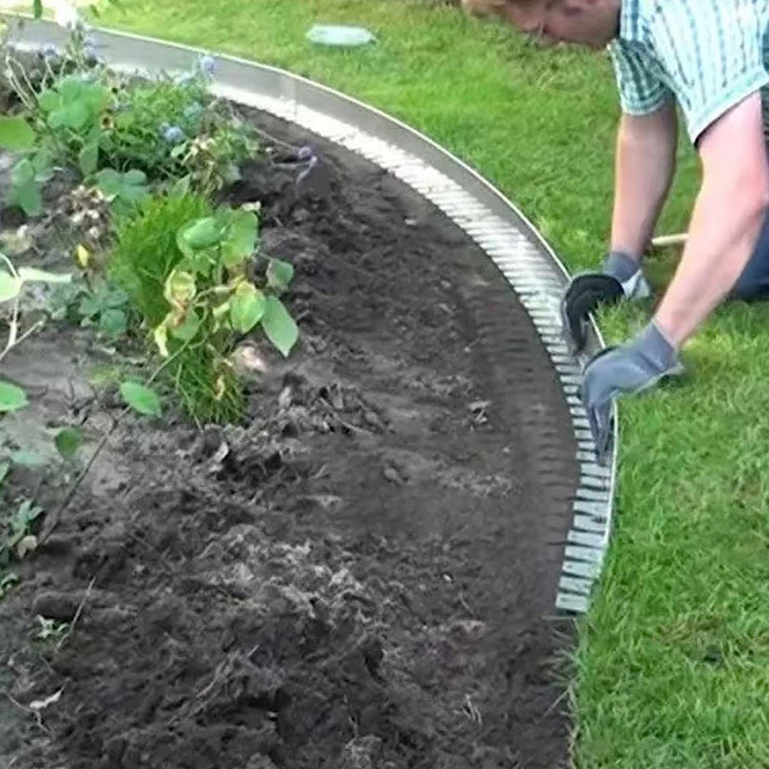 Metal garden edging being positioned along a curved bed